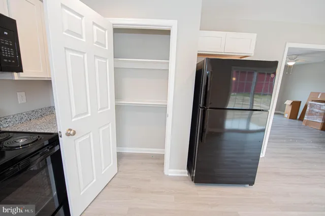 a kitchen with stainless steel appliances granite countertop a refrigerator a sink dishwasher and a stove with wooden floor