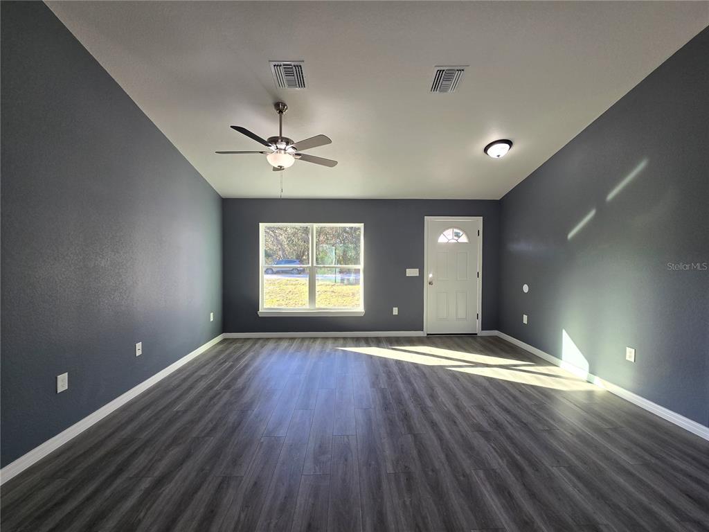 245 Locust Pass Lane Ocala, FL 34472 - Photo 13 of 41 wooden floor in an empty room with a window