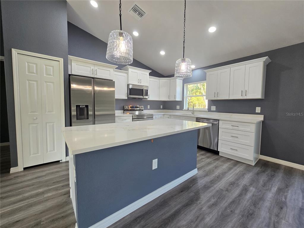 245 Locust Pass Lane Ocala, FL 34472 - Photo 15 of 41 a kitchen with stainless steel appliances granite countertop a sink a stove and a refrigerator