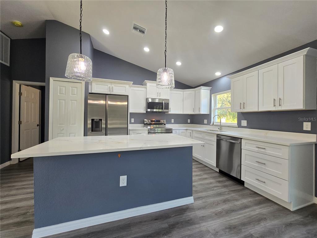 245 Locust Pass Lane Ocala, FL 34472 - Photo 16 of 41 a kitchen with stainless steel appliances granite countertop a sink a stove and a refrigerator