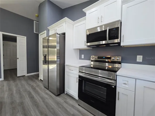 a kitchen with stainless steel appliances a stove a microwave and cabinets