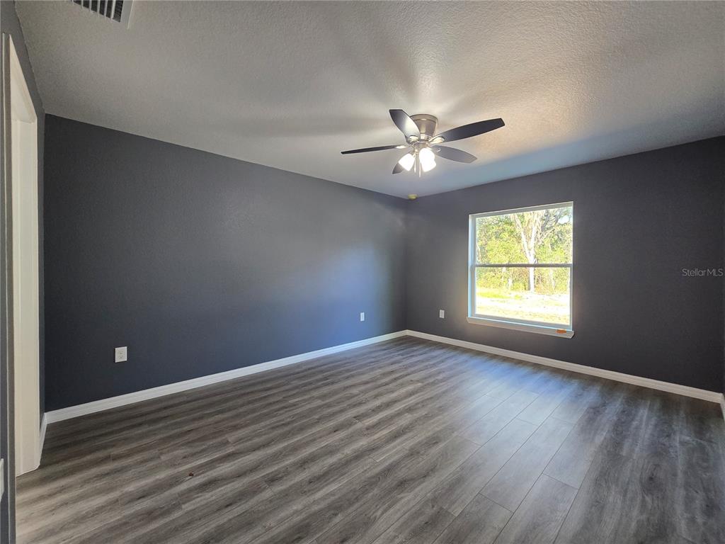 245 Locust Pass Lane Ocala, FL 34472 - Photo 21 of 41 an empty room with wooden floor and windows