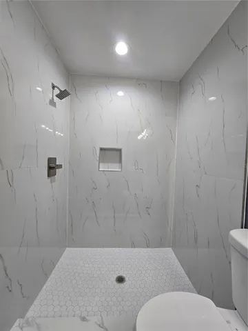 a bathroom with a toilet and a shower