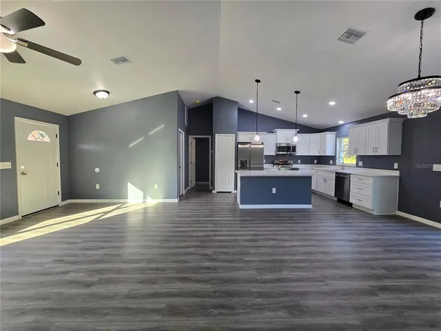 a large kitchen with stainless steel appliances granite countertop a large counter top and a stove