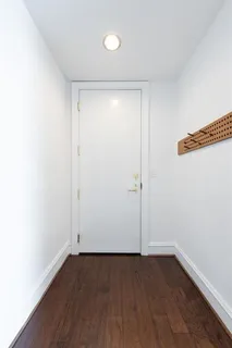 an empty room with wooden floor and white walls