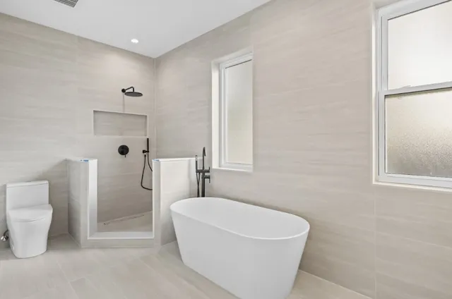 a white bath tub sitting next to a white toilet