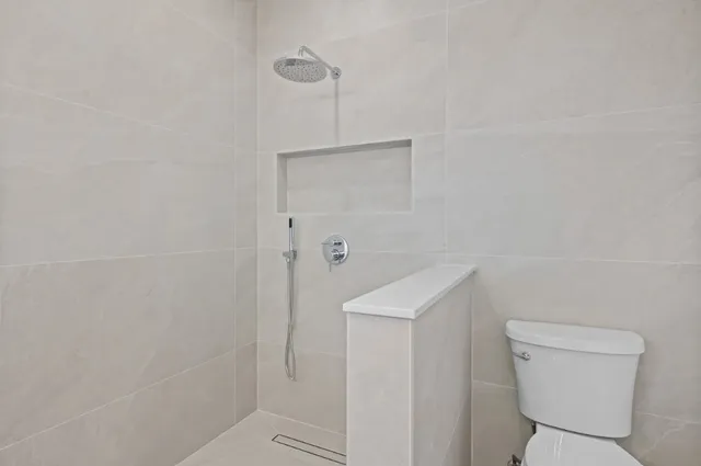 a bathroom with a toilet a sink a shower and mirror