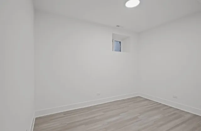 a view of an empty room with wooden floor