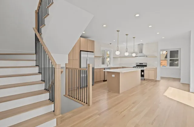 a kitchen with stainless steel appliances kitchen island hardwood floor sink and cabinets