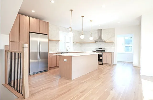a kitchen with kitchen island a counter top space a sink stainless steel appliances and cabinets