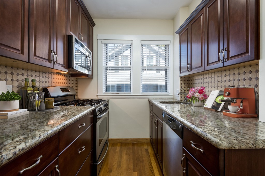 34 Ash Street, Unit 204 Cambridge, MA 02138 - Photo 4 of 10 a kitchen with granite countertop stainless steel appliances window a sink and cabinets