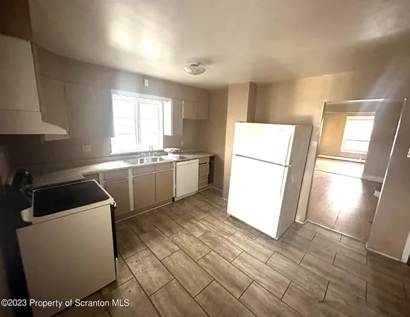 a kitchen with a sink a refrigerator and window