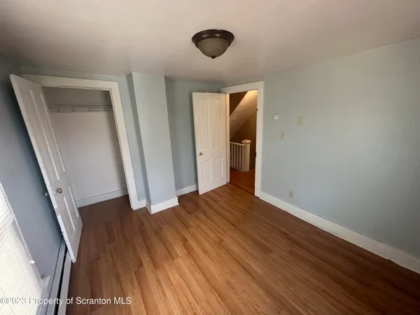a view of a hallway with wooden floor and staircase