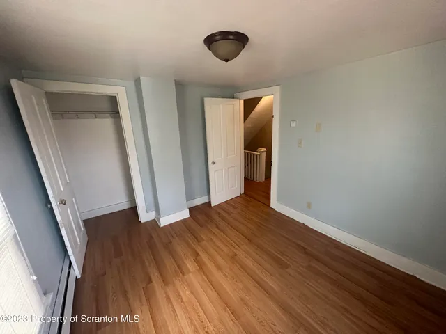 a view of a hallway with wooden floor and staircase