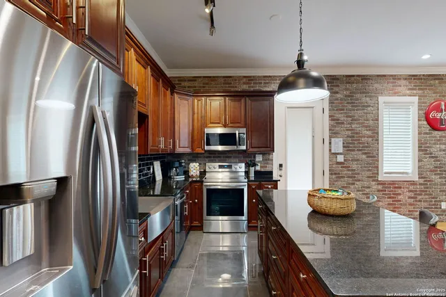 a kitchen with stainless steel appliances granite countertop a refrigerator a sink and a stove