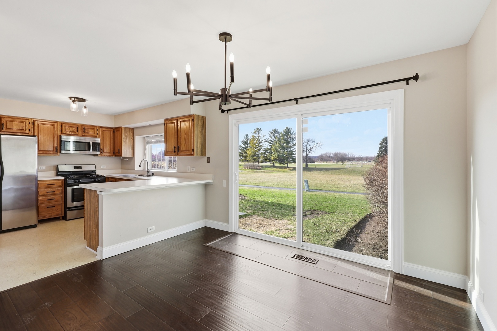 1780 Pebble Beach Circle Elgin, IL 60123 - Photo 3 of 21 a kitchen with a refrigerator a stove top oven and a large window