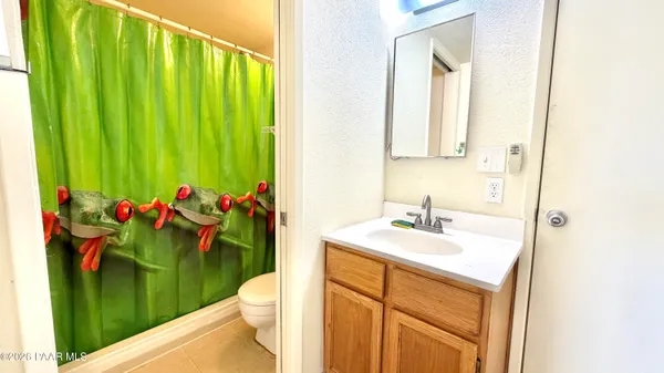 a bathroom with a sink mirror and a toilet