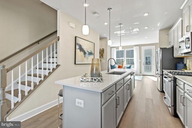 a kitchen with stainless steel appliances granite countertop a sink a stove top oven a counter space and cabinets