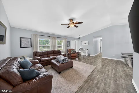 a living room with furniture ceiling fan and a window