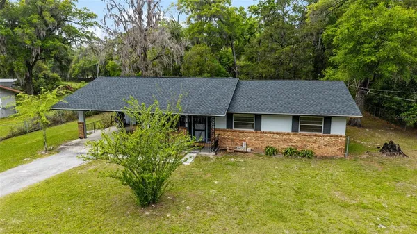 a aerial view of a house with table and chairs under an umbrella