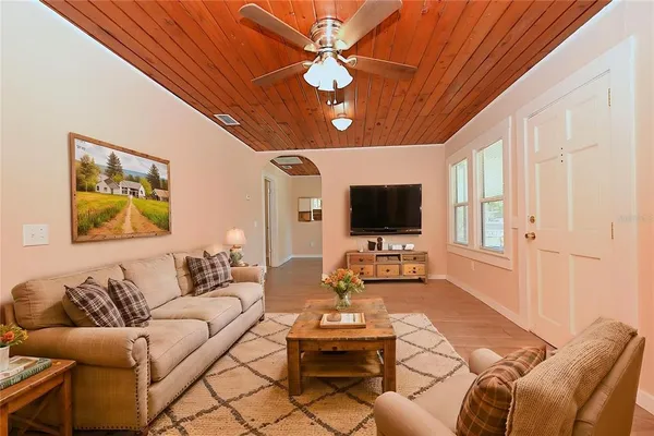 a living room with furniture a flat screen tv and a window