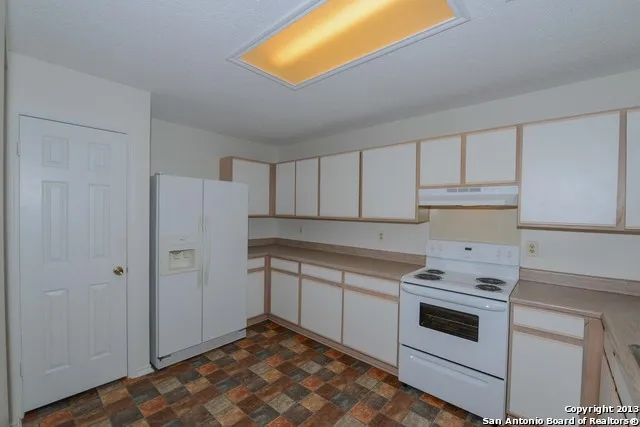 a kitchen with white cabinets and white appliances