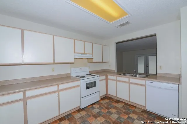 a kitchen with a sink stove and cabinets