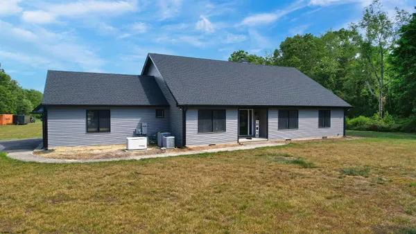 a front view of a house with a garden and yard