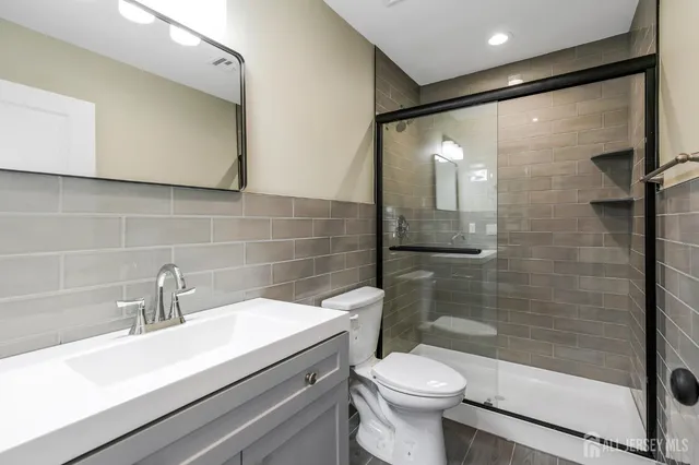 a bathroom with a sink a toilet and shower