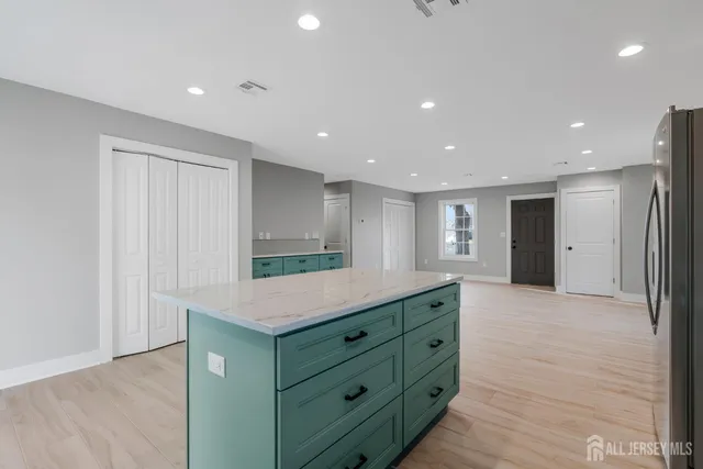 a kitchen with kitchen island a sink stainless steel appliances and cabinets