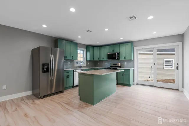 a kitchen with stainless steel appliances granite countertop a refrigerator and a sink
