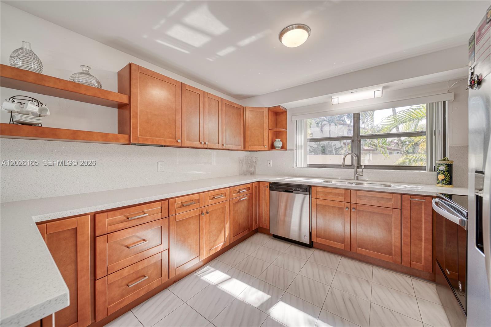 13337 Southwest 64th Lane Miami, FL 33183 - Photo 14 of 36 a kitchen with granite countertop wooden cabinets a sink and appliances