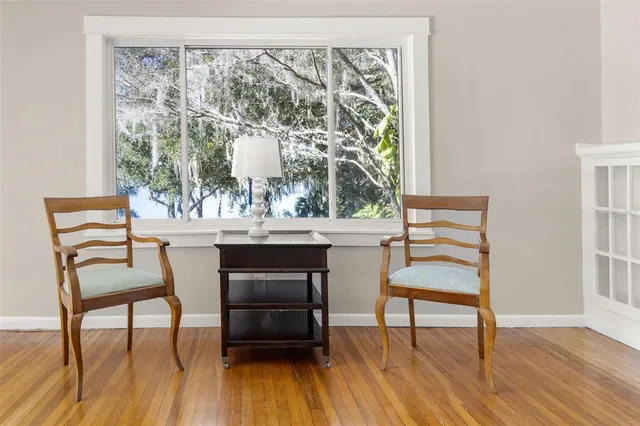 a dining room with wooden floor a glass table and chairs