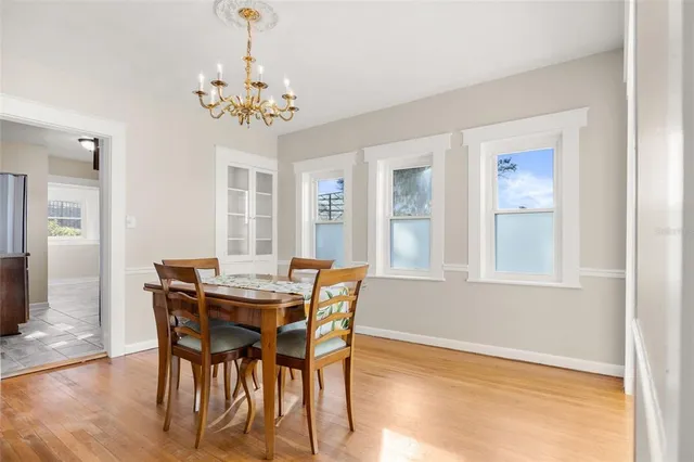 a view of a dining room with furniture a chandelier and wooden floor