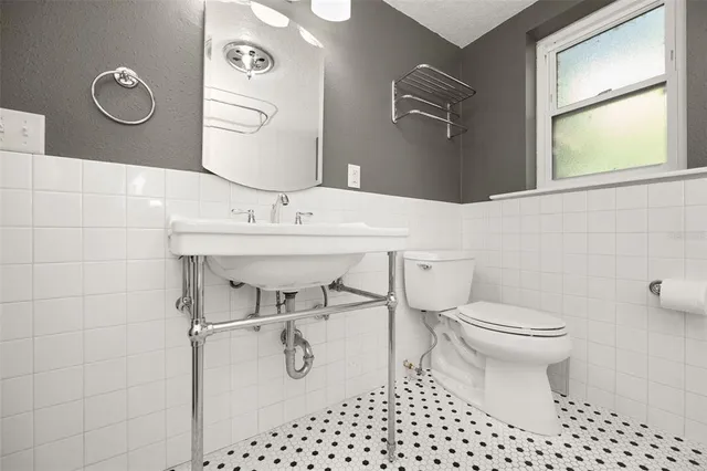 a bathroom with a sink toilet and a mirror