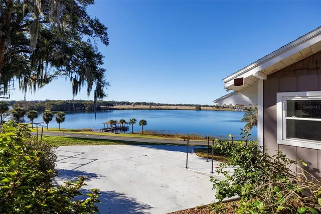 a view of a swimming pool with a lawn chairs under an umbrella