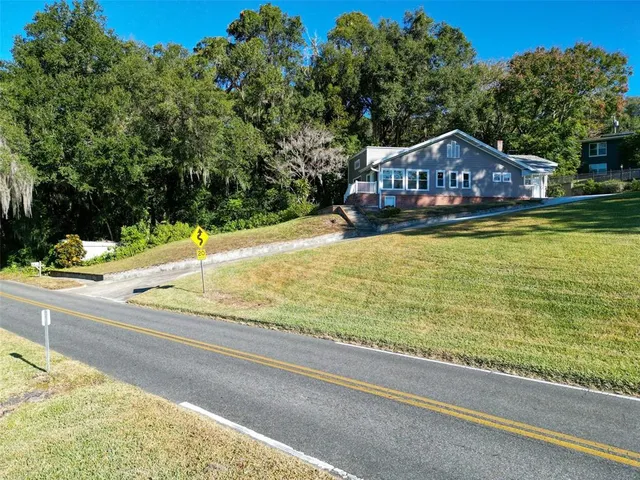 a front view of house with yard and trees around