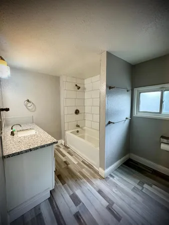 a bathroom with a granite countertop sink and a mirror
