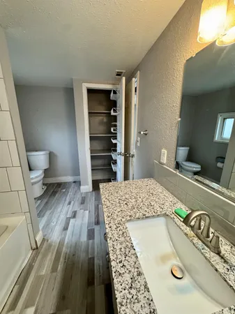 a large kitchen with stainless steel appliances granite countertop a stove a sink dishwasher and a microwave oven on the wooden floor
