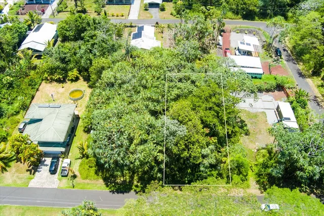 an aerial view of residential house with outdoor space and trees all around