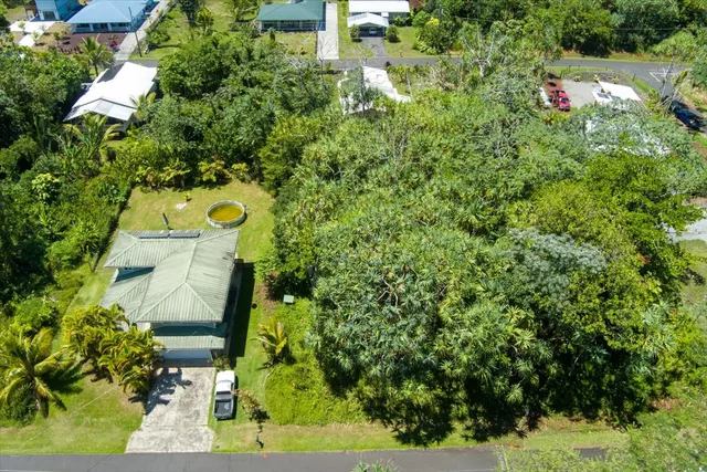 an aerial view of a house with swimming pool and garden view