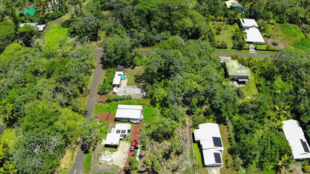 an aerial view of residential house with outdoor space and trees all around