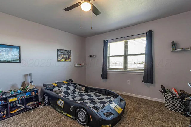 a bedroom with a bed and a chandelier fan