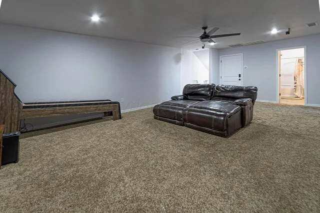 a living room with furniture a ceiling fan and a rug