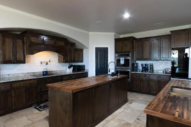 a kitchen with stainless steel appliances granite countertop a sink a stove and a refrigerator