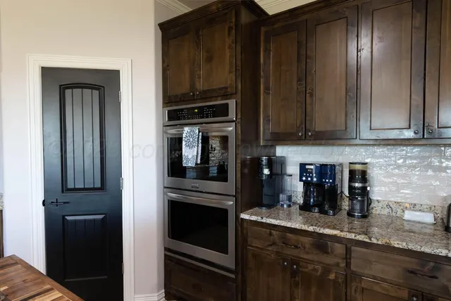 a kitchen with granite countertop stainless steel appliances a refrigerator and cabinets