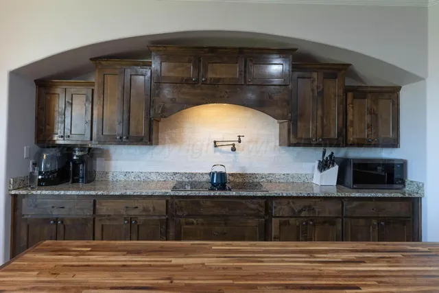 a kitchen with stainless steel appliances granite countertop a sink a stove and cabinets