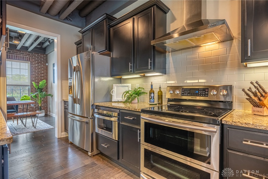 407 Brownstone Row Springboro, OH 45066 - Photo 17 of 54 This kitchen features stainless steel appliances, dark cabinetry, and sleek countertops, ideal for culinary enthusiasts.