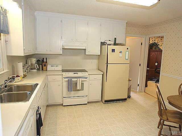 5015 Raintree Road Durham, NC 27712 - Photo 4 of 10 a white kitchen with sink and refrigerator