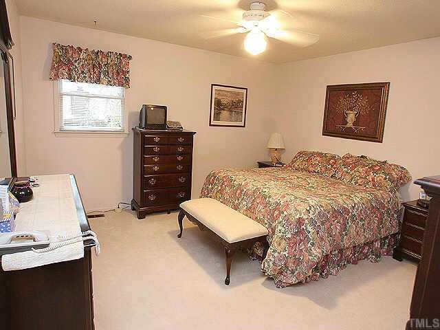 5015 Raintree Road Durham, NC 27712 - Photo 7 of 10 a bedroom with a bed and a couch